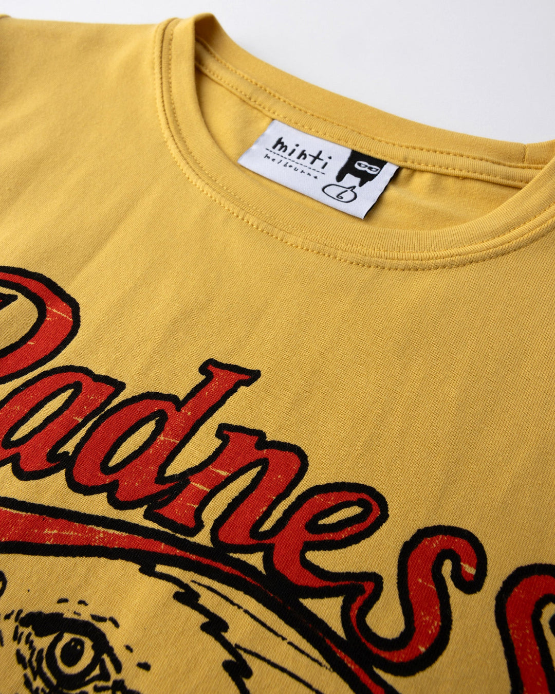 Close up detail of the Radness Tee in dull yellow