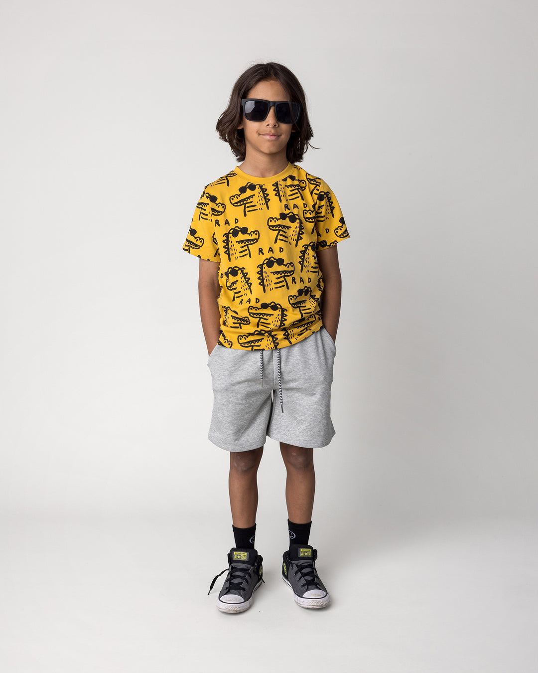 Kid wearing the Rad Croc Tee in mustard with the Smile Short in grey marle, front view