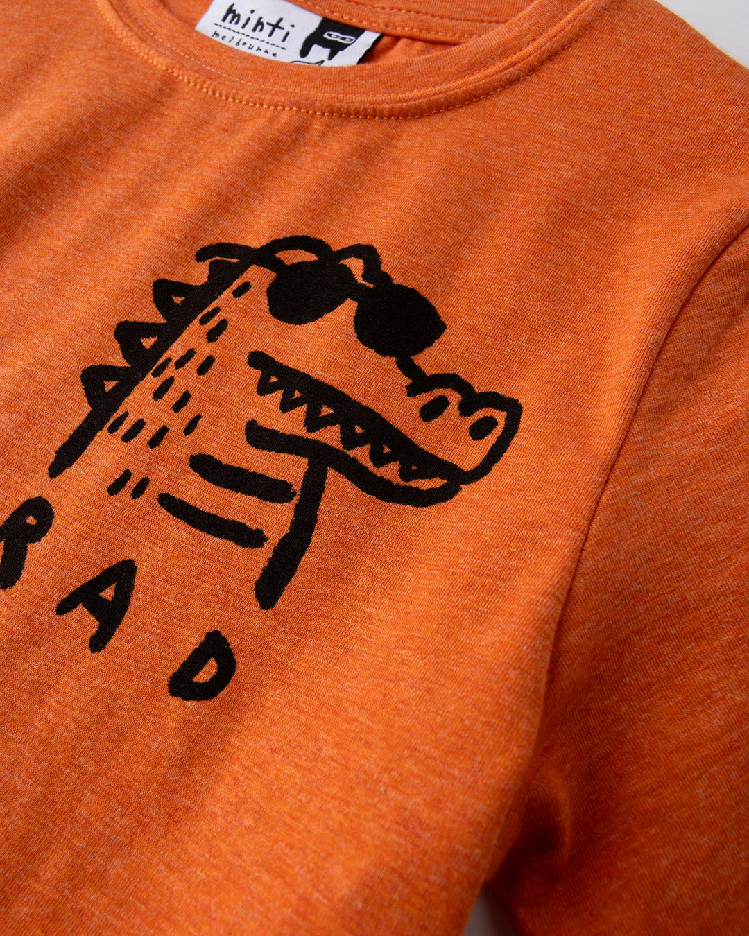 Close up of the Rad Croc Tee print in orange marle