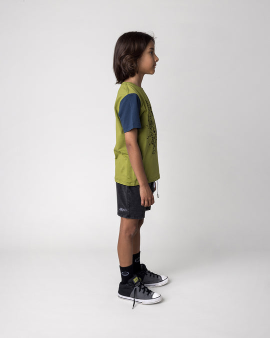 Kid wearing the Rock Griffin Tee in olive, ink and melon with the Blasted Panel Short in black wash, side view