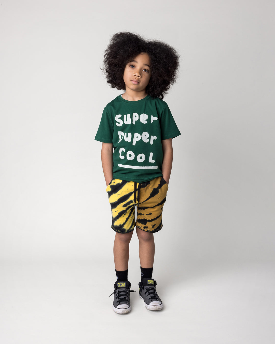 Kid wearing the Super Duper Cool Tee in jungle with the Duo Tie Dye Short in lemon and rust, front view