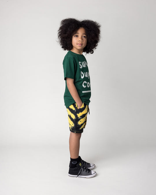 Kid wearing the Super Duper Cool Tee in jungle with the Duo Tie Dye Short in lemon and rust, side view