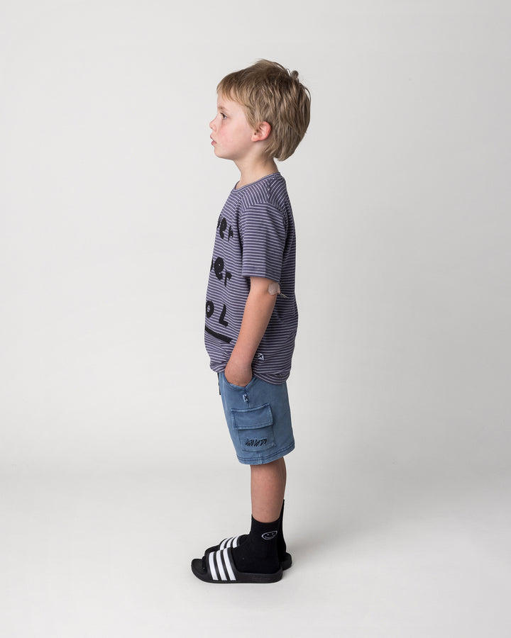 Kid wearing the Super Duper Cool Tee in storm stripe with the Blasted Deluxe Cargo Short in midnight wash, side view