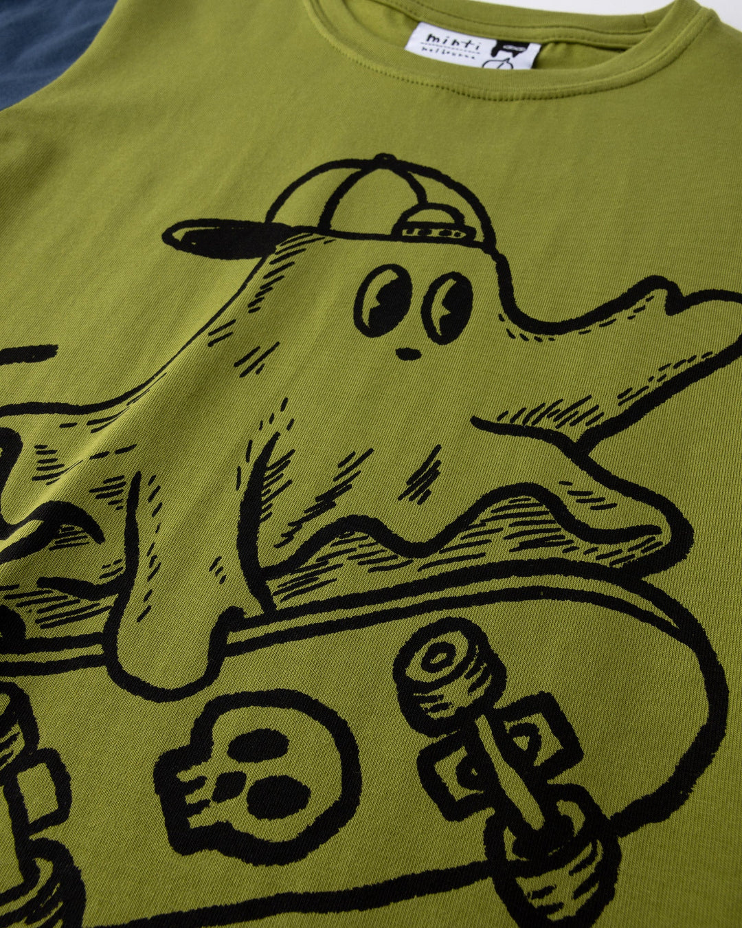 Close up of the Skate Ghost Tee print in olive, ink and mustard