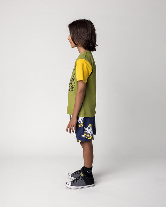 Kid wearing the Skate Ghost Tee in olive, ink and mustard with the Skate Ghost Short in dark blue, side view