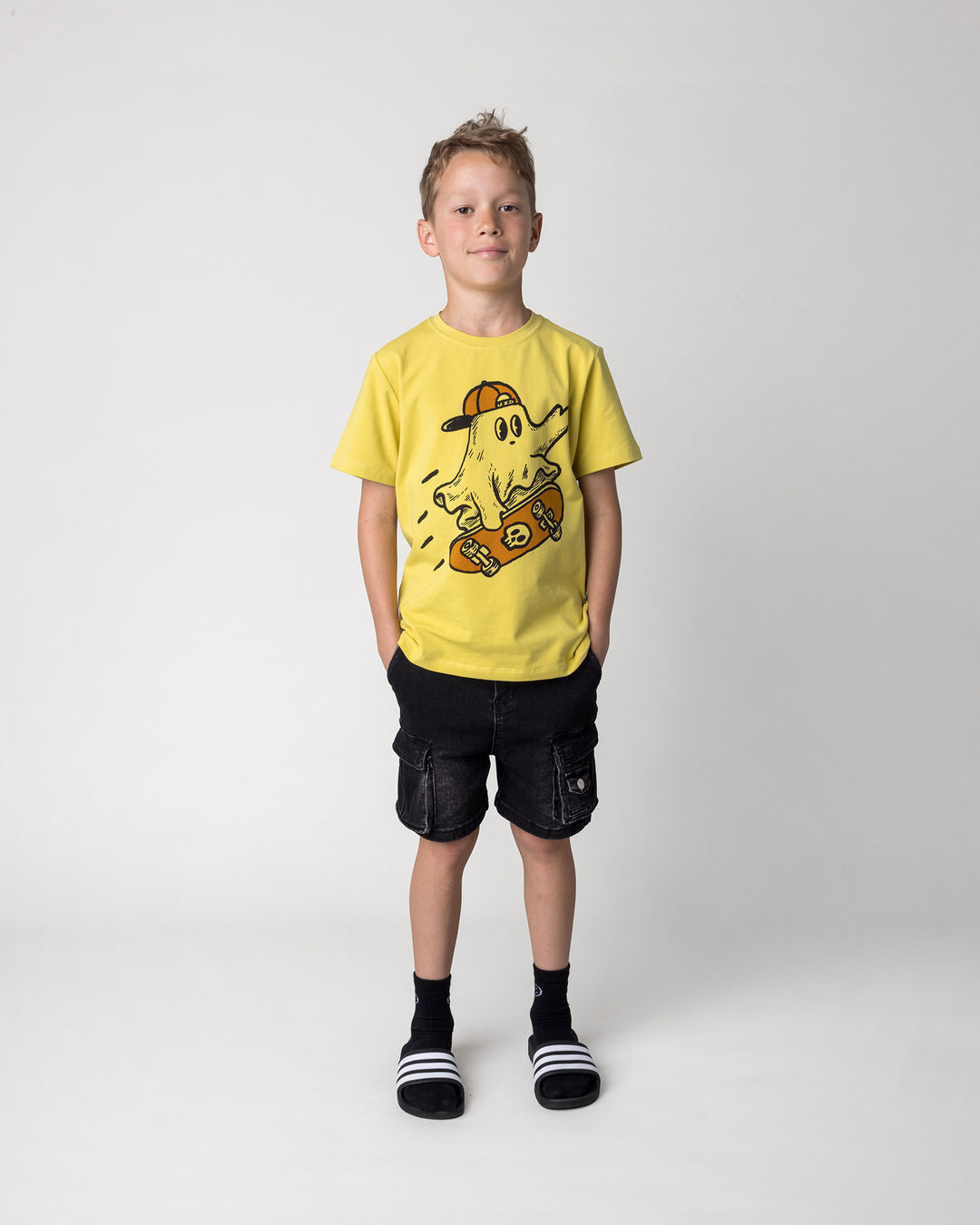 Kid wearing the Skate Ghost Tee in zest, front view