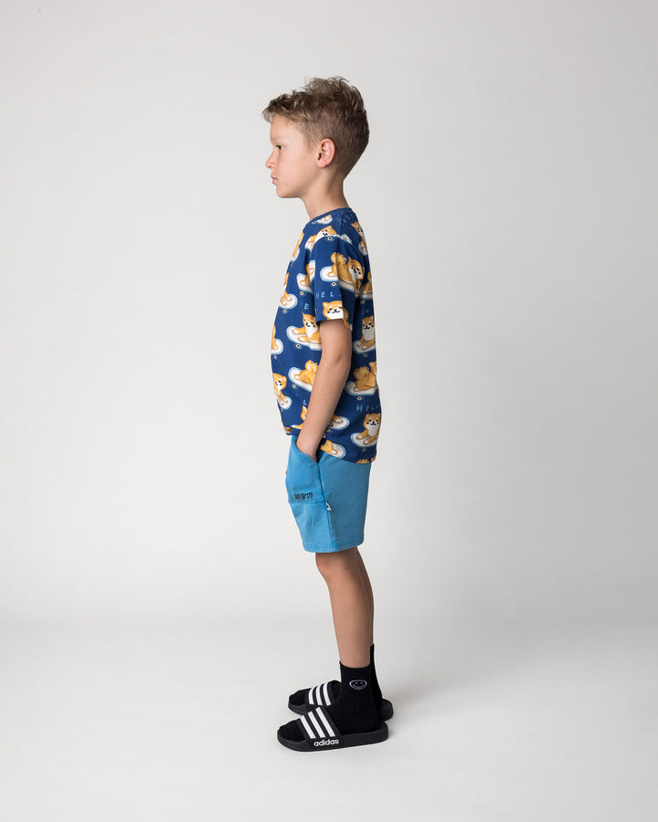 Kid wearing the Skate Puppy Tee in midnight with the Blasted Track Short in sky wash, side view