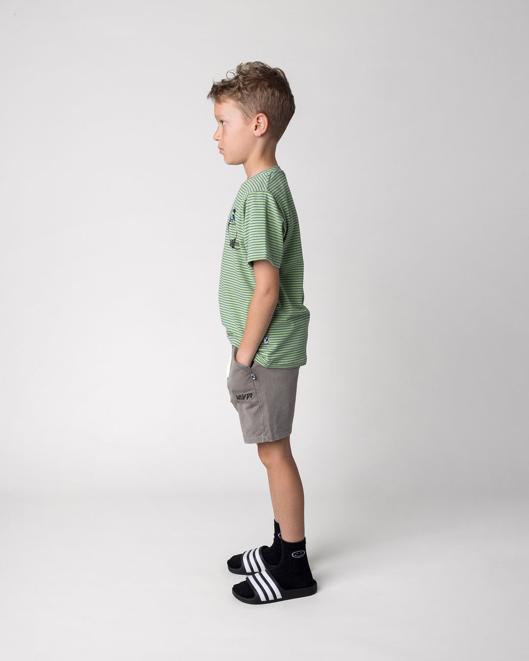 Kid wearing the Skate Panda Tee in lime stripe with the Blasted Track Short in grey wash, side view