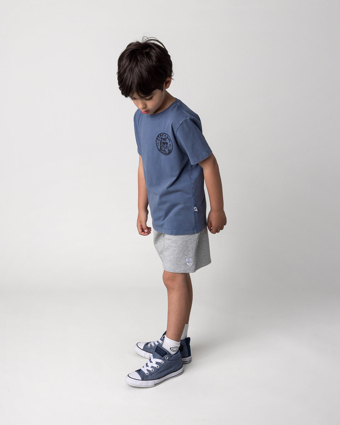 Kid wearing the Stay Cool Tee in blue wash with the Smile Short in grey marle, side view