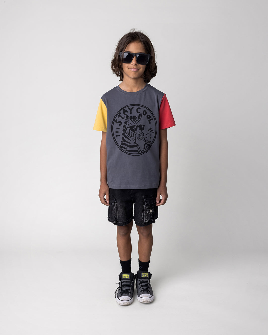 Kid wearing the Stay Cool Tee in dark grey, yellow and melon, front view