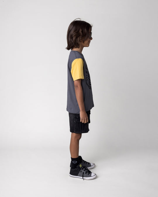 Kid wearing the Stay Cool Tee in dark grey, yellow and melon, side view