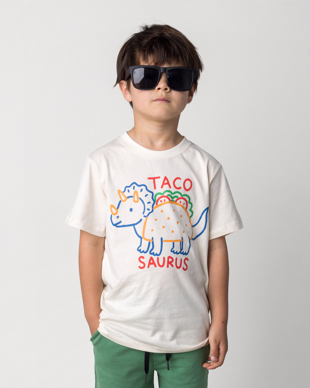 Close up of the Taco Saurus Tee in cream on a kid, front view