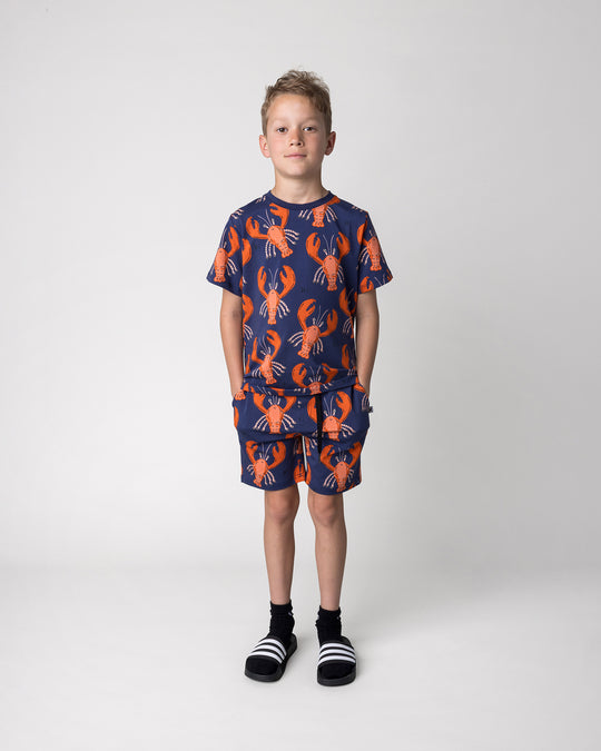 Kid wearing the Vacay Crayfish Tee in midnight with the Vacay Crayfish Short in midnight, front view