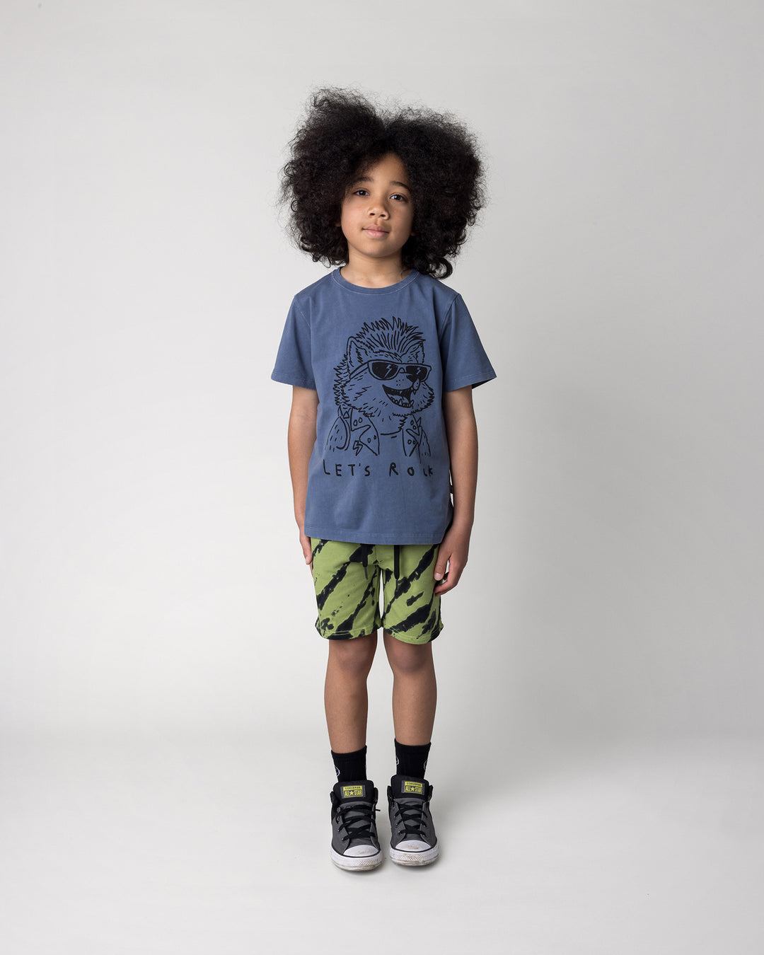 Kid wearing the Werewolf Rockstar Tee in blue wash with the Strike Short in lime, front view