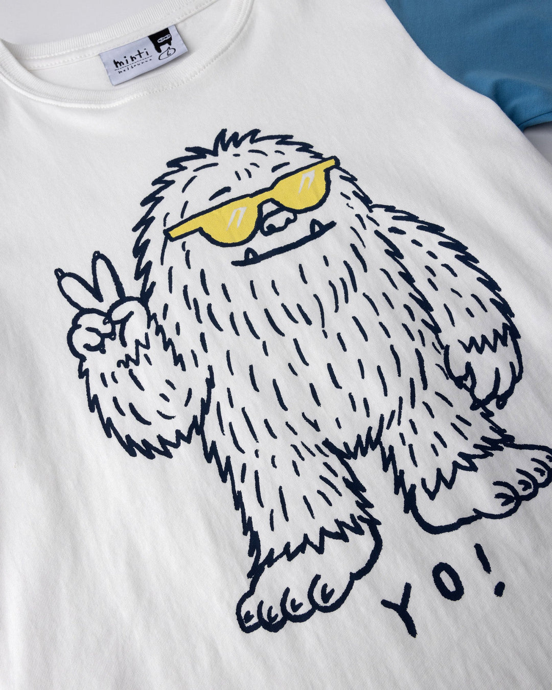 Close up of the Yo Yeti Tee print in white, orange and steel