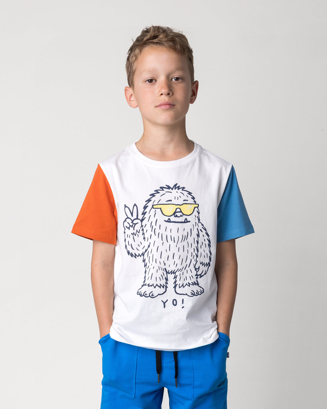 Close up of the Yo Yeti Tee in white, orange and steel on a kid, front view