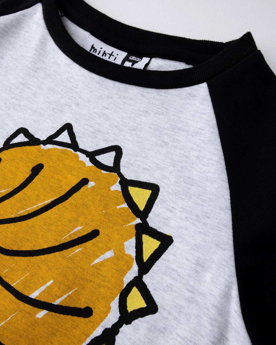 Close up of the Cool Dino Tee print in white marle and black