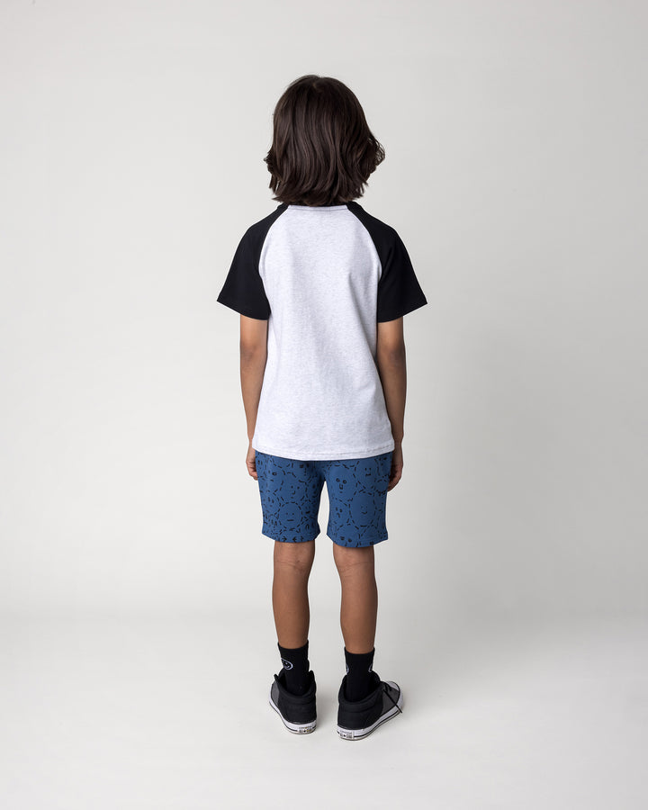Kid wearing the Later Gator Tee in white marle and black with the Different Faces Short in midnight, back view