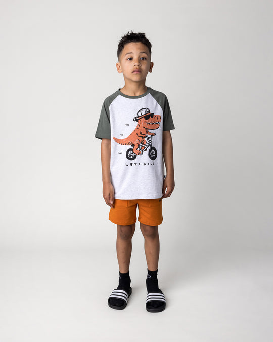 Kid wearing the Rex Rider Tee in white marle and forest with the Track Short in burnt orange, front view