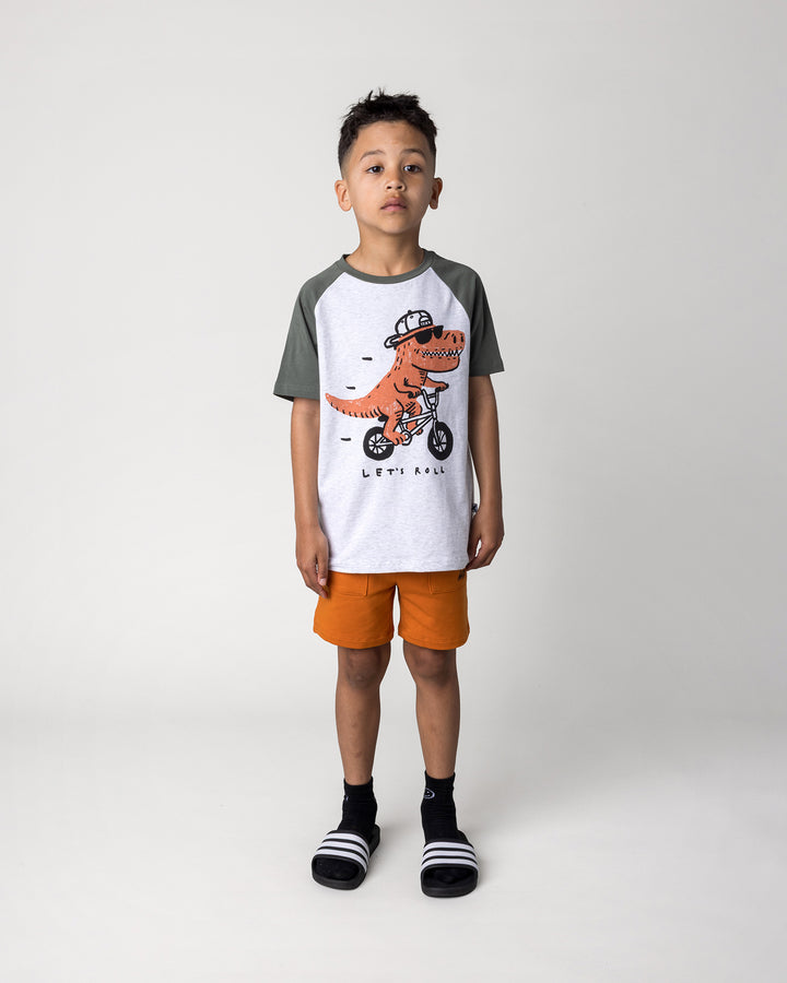 Kid wearing the Rex Rider Tee in white marle and forest with the Track Short in burnt orange, front view