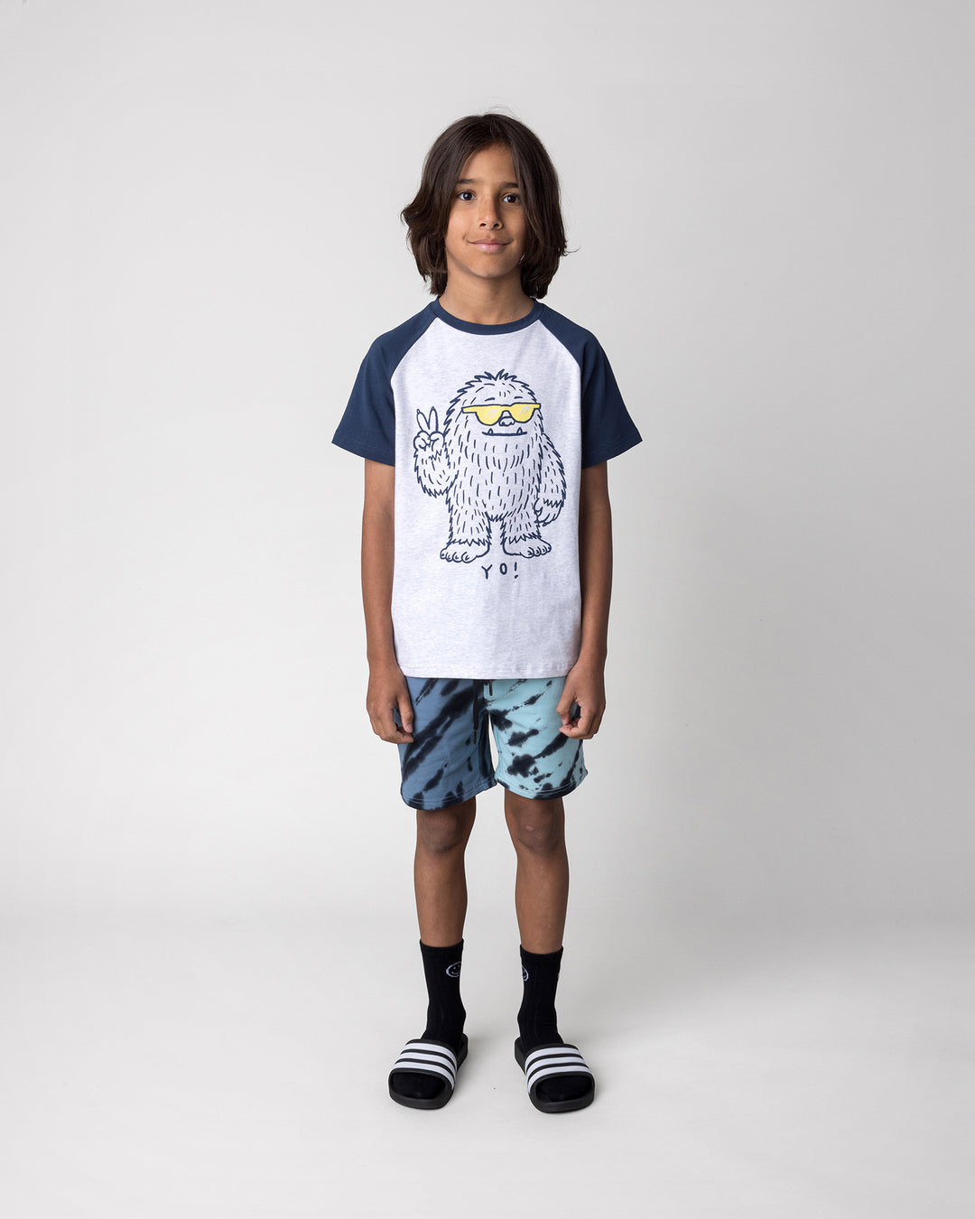 Kid wearing the Yo Yeti Tee in white marle and ink with the Duo Tie Dye Short in blue and aqua, front view