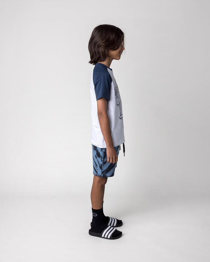 Kid wearing the Yo Yeti Tee in white marle and ink with the Duo Tie Dye Short in blue and aqua, side view