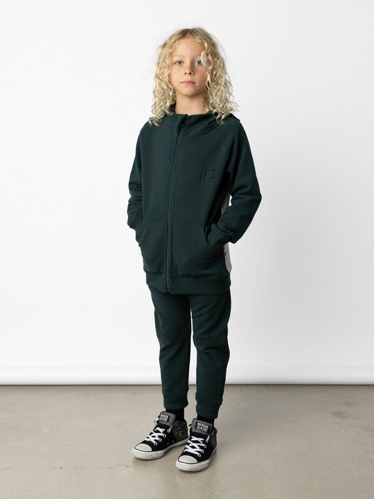 Minti kids clothing. Cosy zip through hoodie with kangaroo pockets for extra warmth! 2x2 rib trim on the hood, cuffs and hem. Small embroidery on the front and big print on the back. 330 Gram // Brushed Inside // 95% Cotton // 5% Elastane.