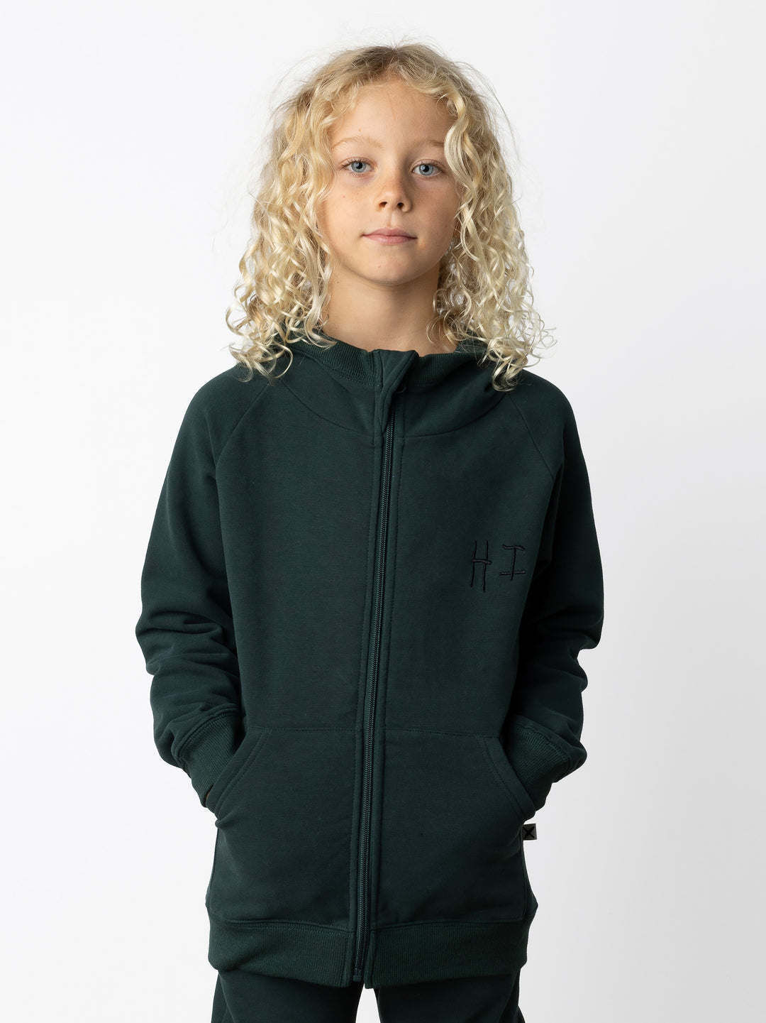 Minti kids clothing. Cosy zip through hoodie with kangaroo pockets for extra warmth! 2x2 rib trim on the hood, cuffs and hem. Small embroidery on the front and big print on the back. 330 Gram // Brushed Inside // 95% Cotton // 5% Elastane.