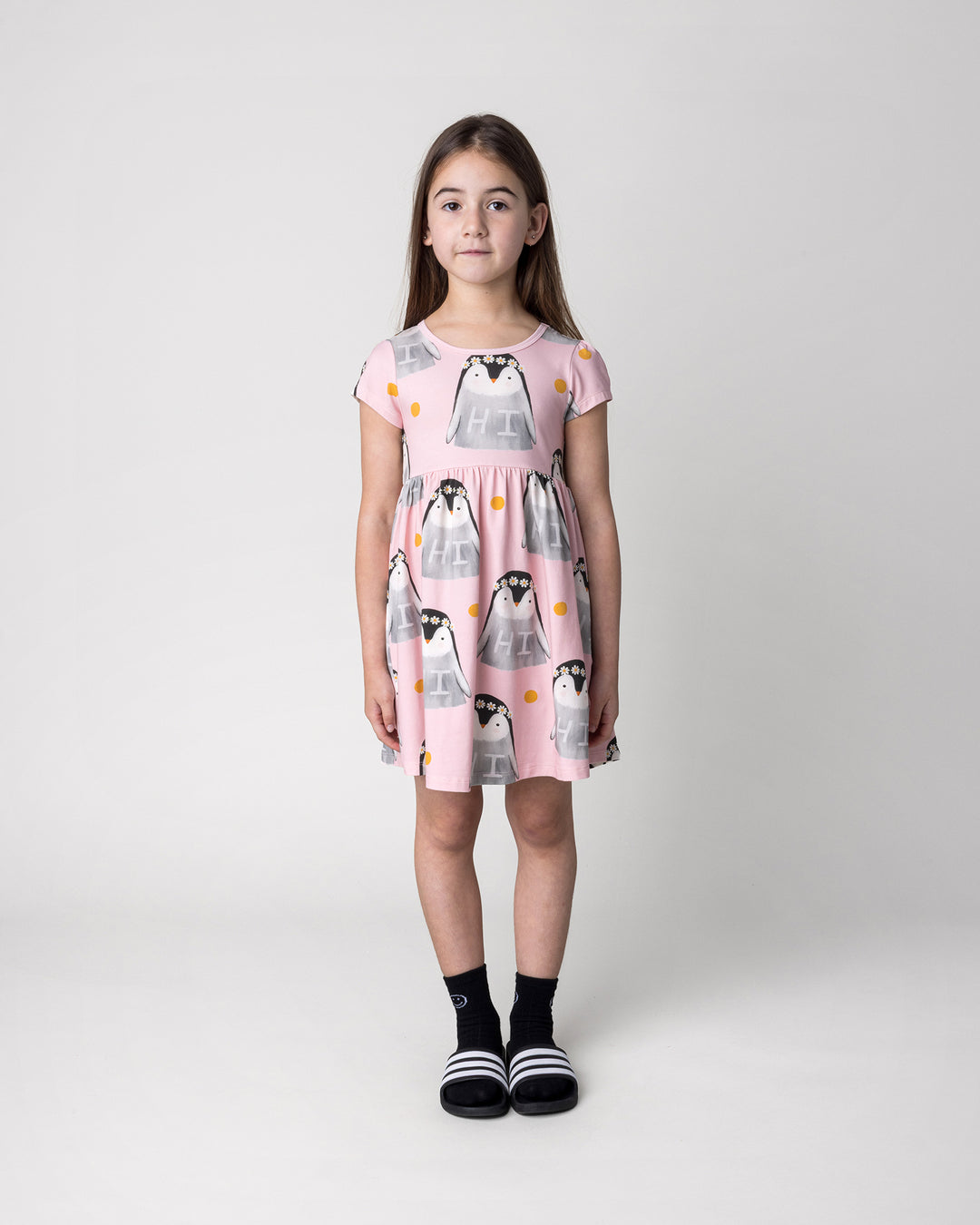 Kid wearing the Flower Penguin Dress in pink, front view