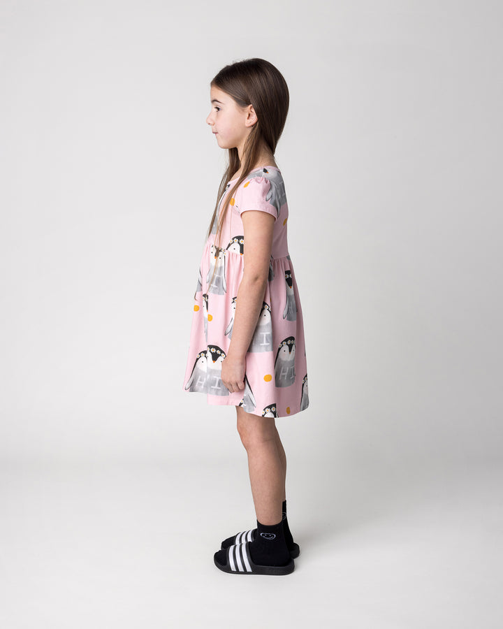 Kid wearing the Flower Penguin Dress in pink, side view