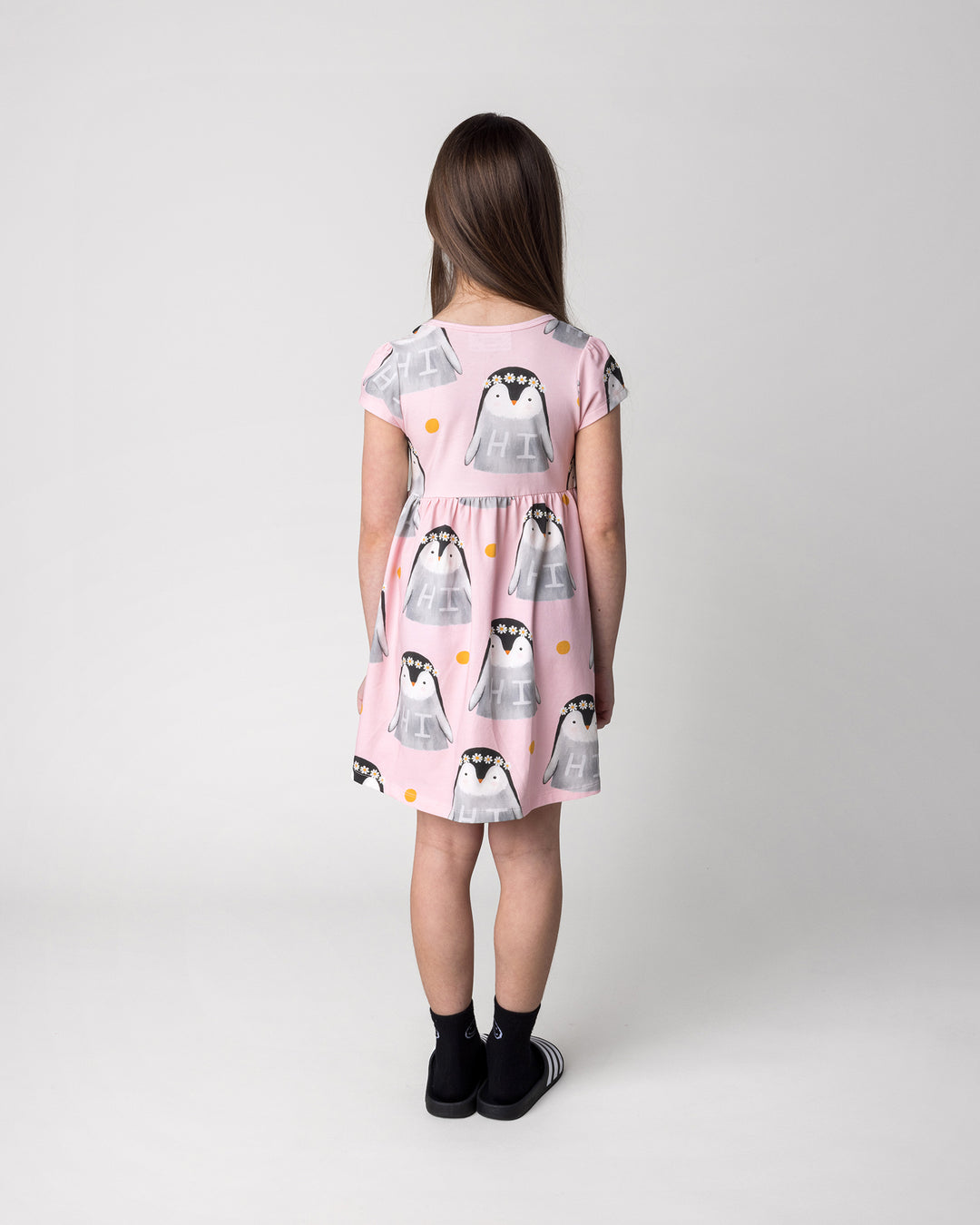 Kid wearing the Flower Penguin Dress in pink, back view