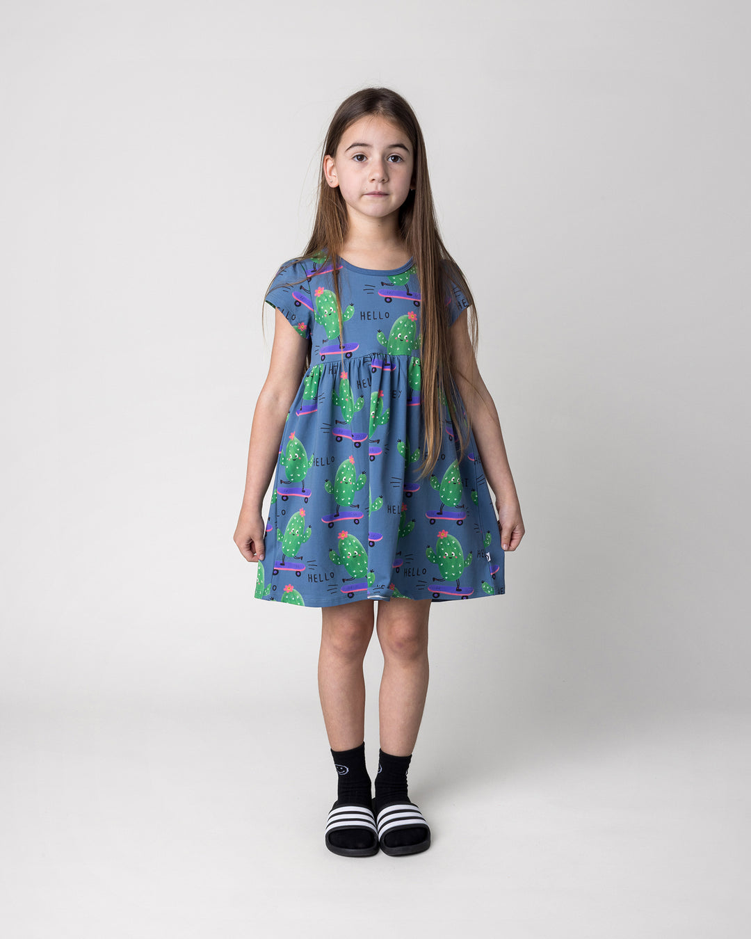 Kid wearing the Skate Cactus Dress in muted blue, front view
