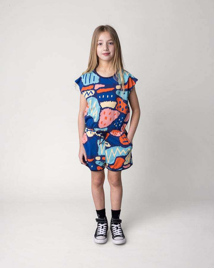 Kid wearing the Cool Shapes Playsuit in dark blue, front view