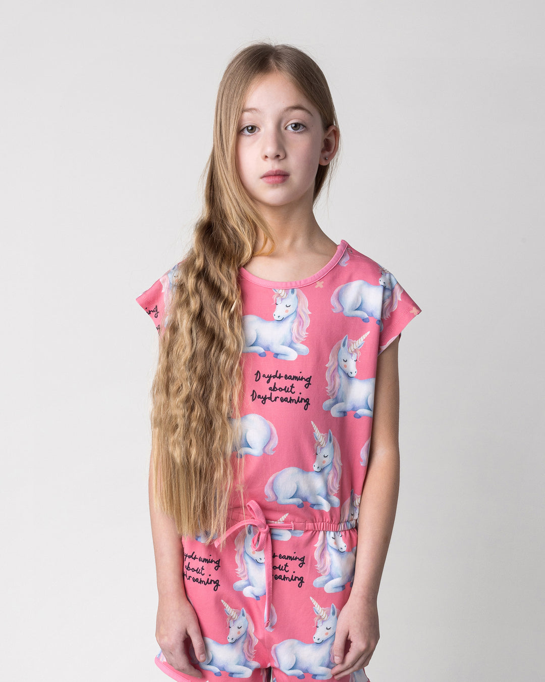 Close up of the Daydreaming Unicorn Playsuit in candy on a kid, front view