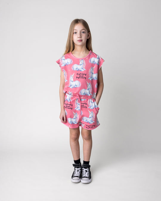 Kid wearing the Daydreaming Unicorn Playsuit in candy, front view