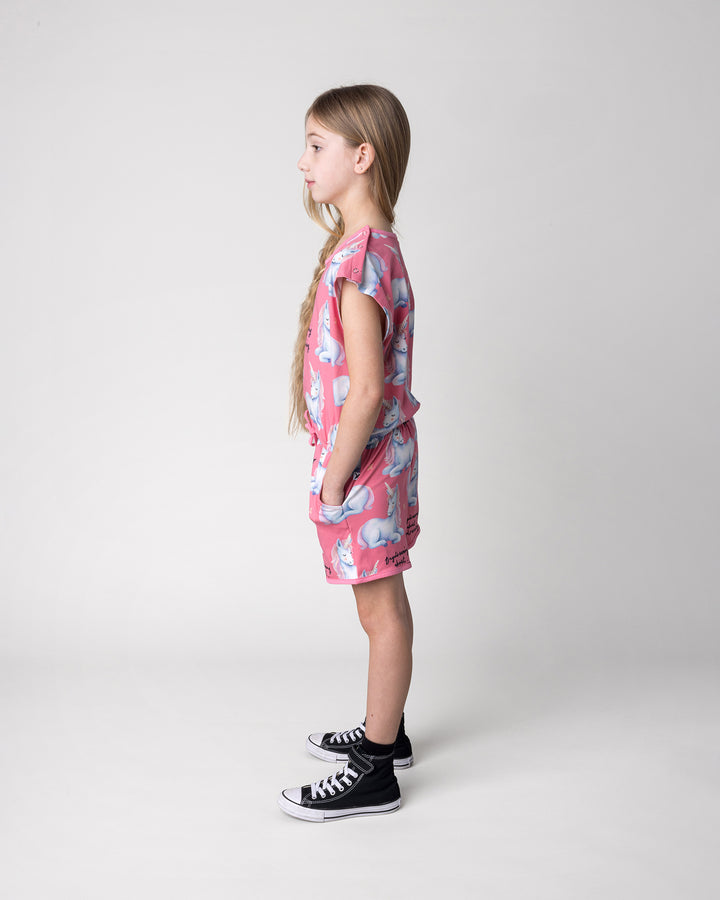 Kid wearing the Daydreaming Unicorn Playsuit in candy, side view