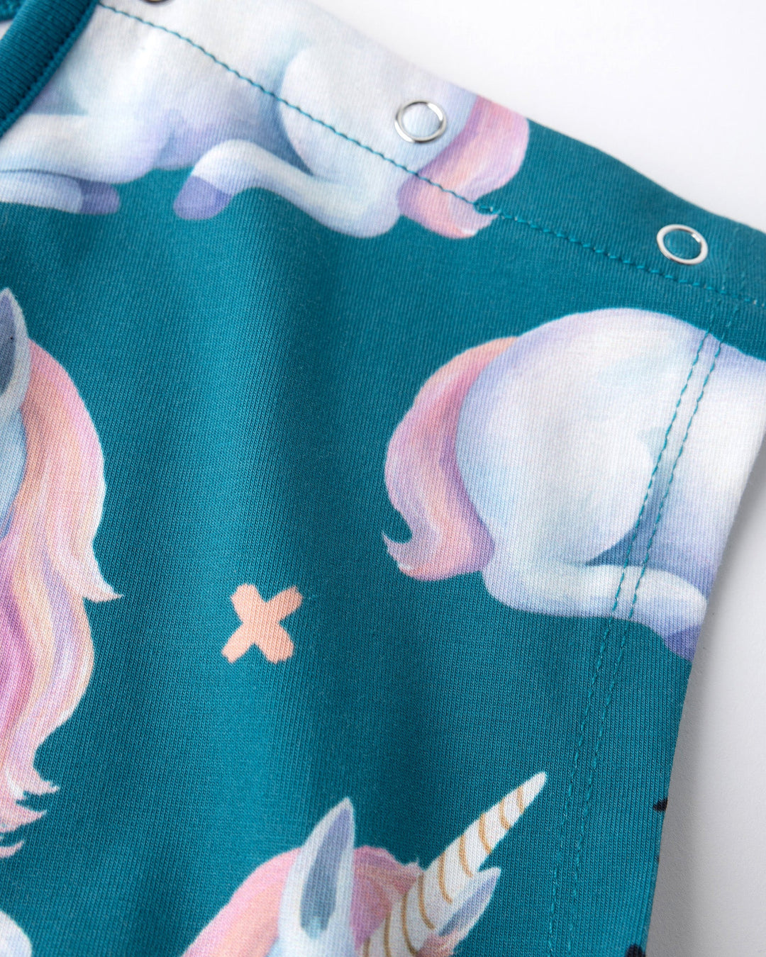 Close up of the Daydreaming Unicorn Playsuit print in teal