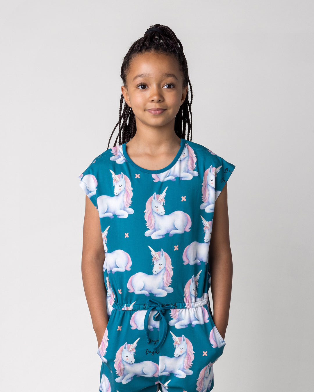 Close up of the Daydreaming Unicorn Playsuit in teal on a kid, front view