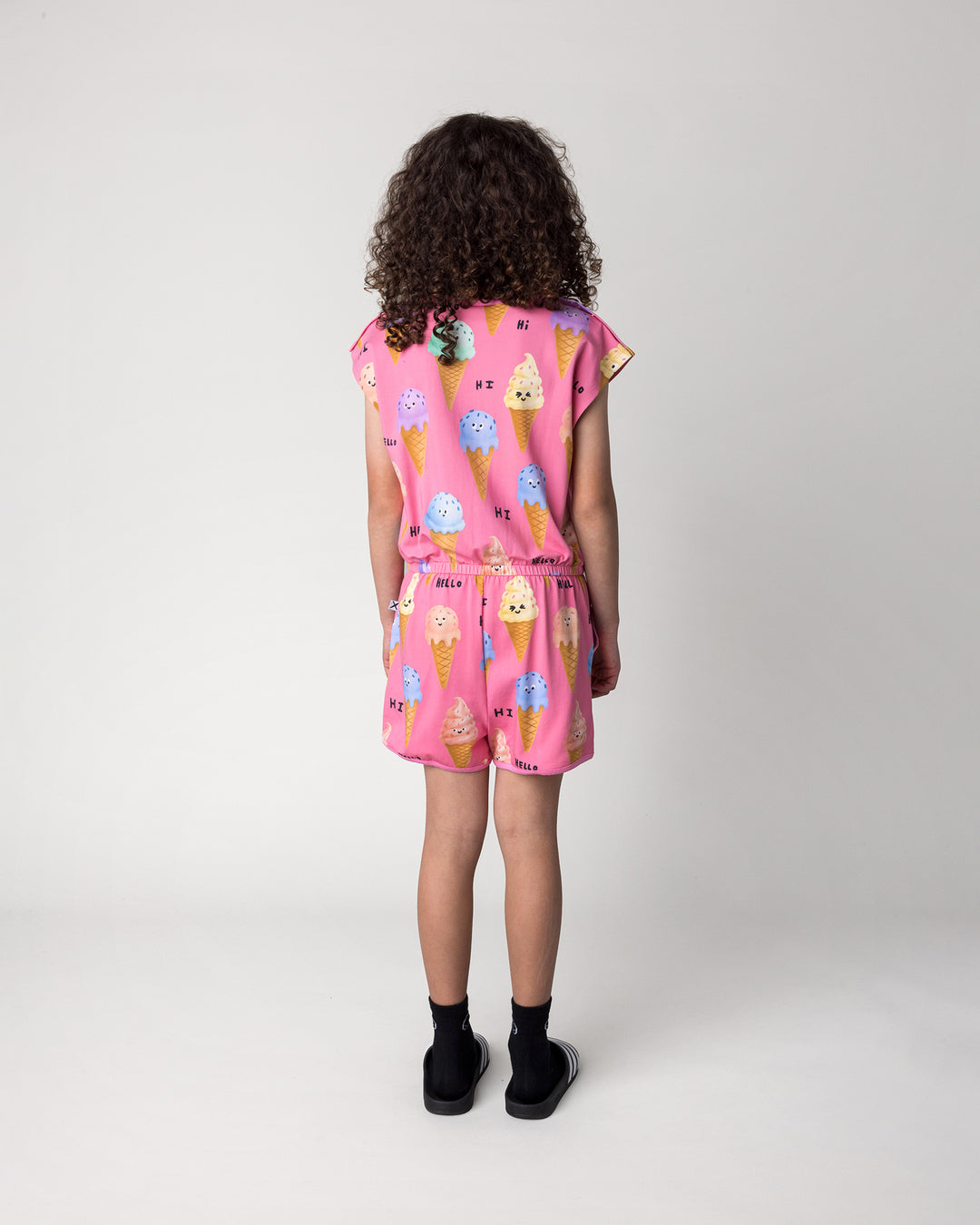 Kid wearing the Happy Icecreams Playsuit in pink, back view