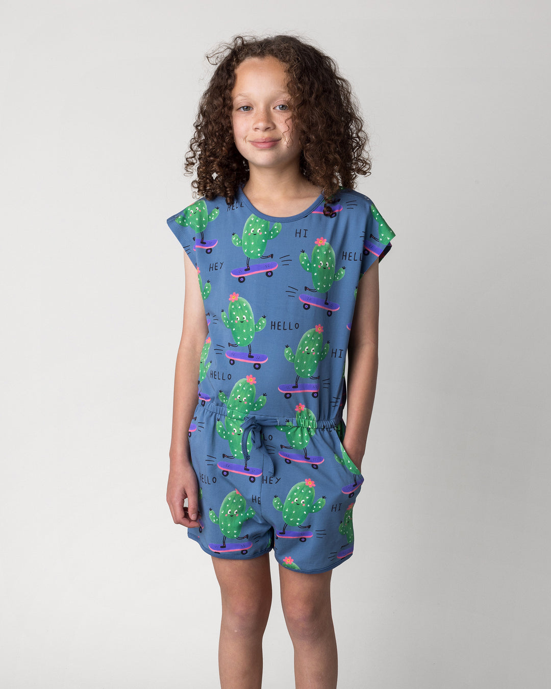 Close up of the Skate Cactus Playsuit in muted blue on a kid, front view