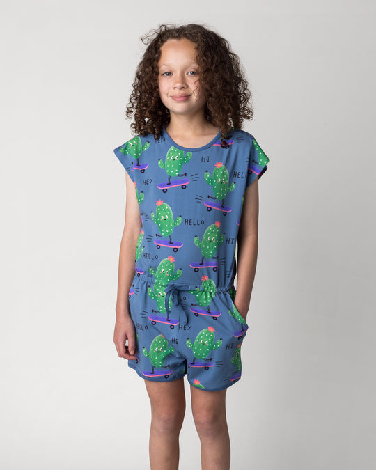 Close up of the Skate Cactus Playsuit in muted blue on a kid, front view