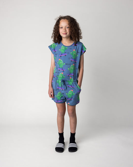 Kid wearing the Skate Cactus Playsuit in muted blue, front view