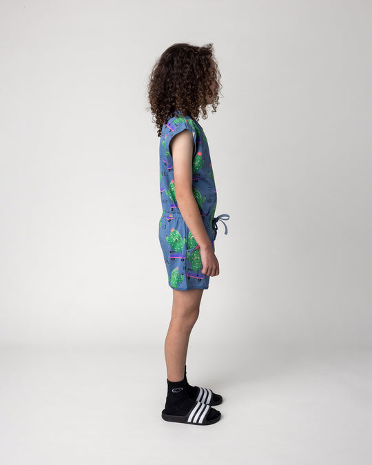Kid wearing the Skate Cactus Playsuit in muted blue, side view