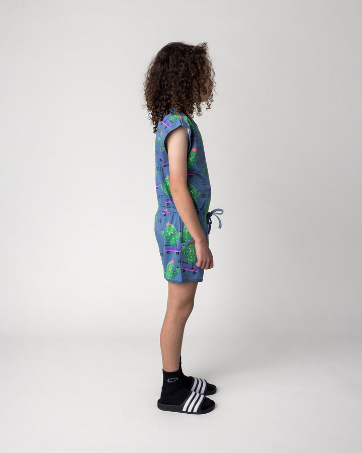 Kid wearing the Skate Cactus Playsuit in muted blue, side view