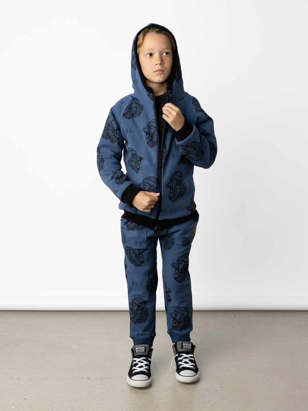 Minti kids clothing. Super cosy two-in-one Zip Up! One side is plain black with a kangaroo front pocket, the other side has our awesome Roar yardage and a contrast HI embroidery! Perfect for all occasions and super warm! 330 Gram // Brushed Inside // 95% Cotton // 5% Elastane.