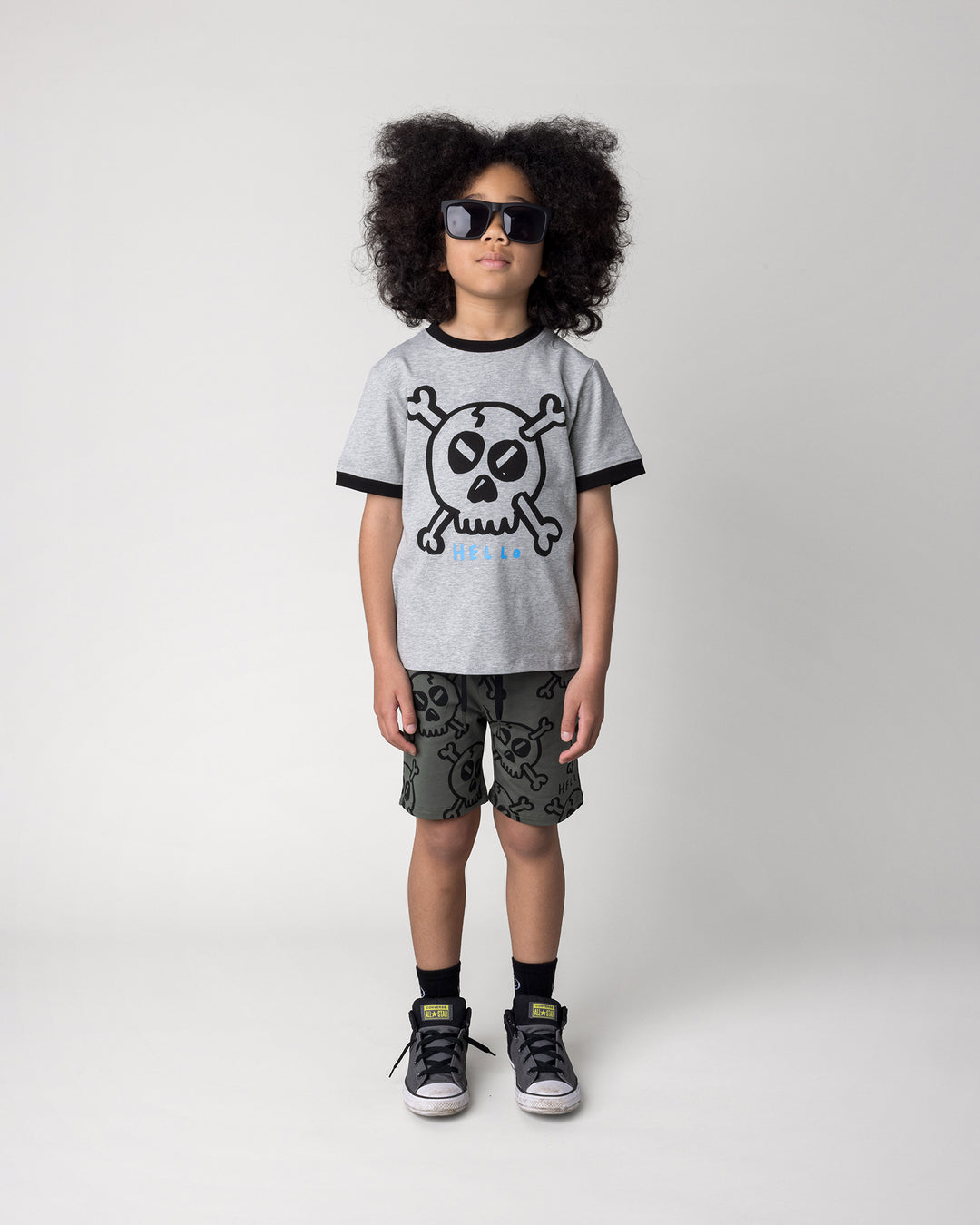 Kid wearing the Hello Skull Short in forest with the Hello Skull Tee in grey marle and black, front view