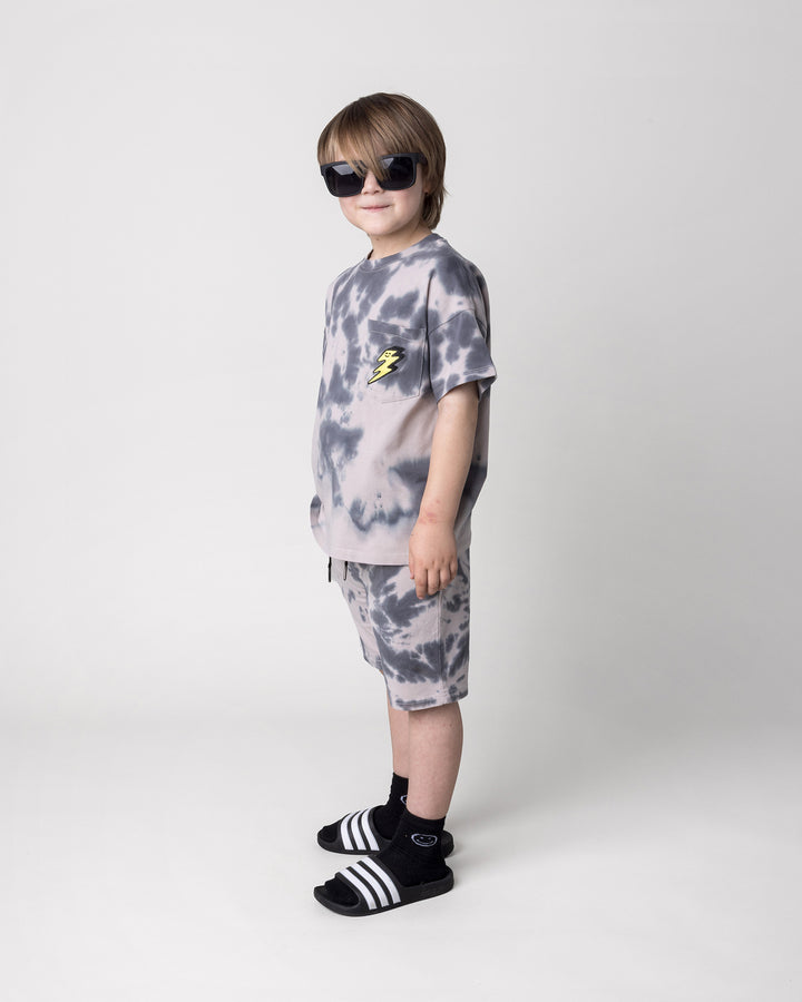 Kid wearing the Splatter Short in grey with the Splatter Tee in grey, side view