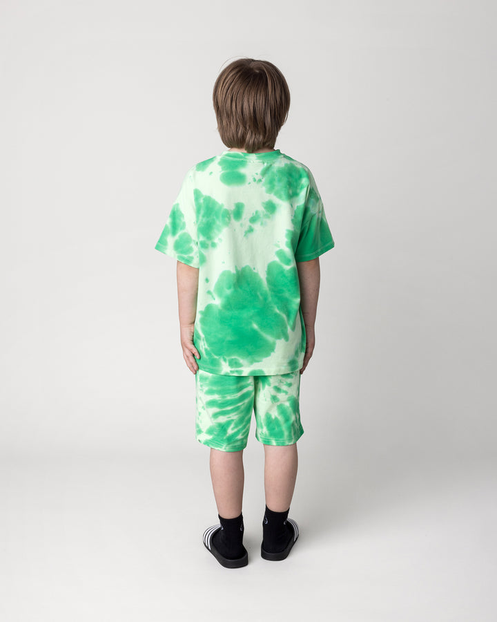 Kid wearing the Splatter Short in green with the Splatter Tee in green, back view