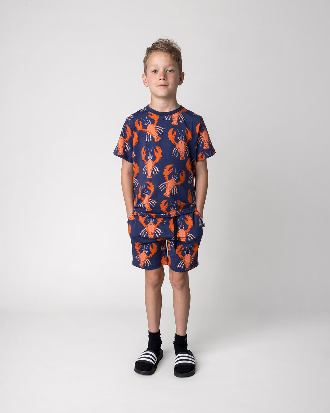 Kid wearing the Vacay Crayfish Short in midnight with the Vacay Crayfish Tee in midnight, front view