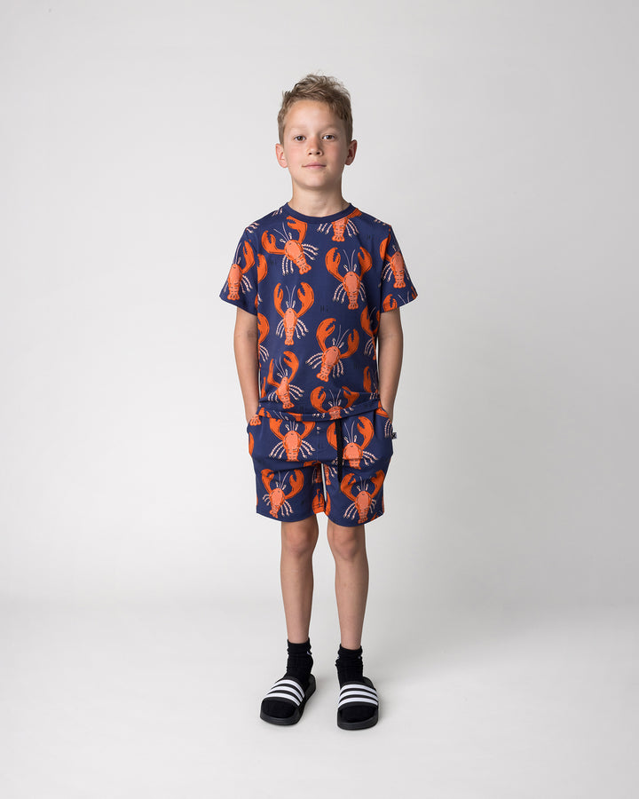 Kid wearing the Vacay Crayfish Short in midnight with the Vacay Crayfish Tee in midnight, front view